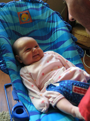 Darcie, smiling at her dad, 6 wks