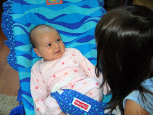 Darcie, smiling at her sister, 6 wks